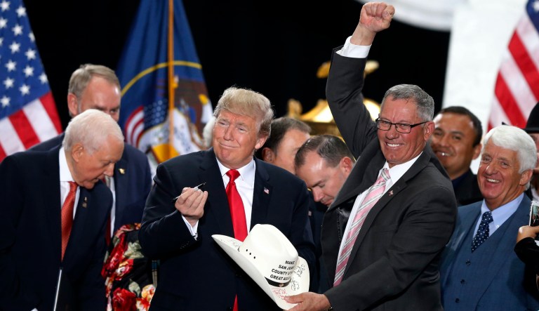 In this Dec. 4, 2017, file photo, President Donald Trump signs the hat of Bruce Adams, chairman of the San Juan County Commission, after signing a proclamation to shrink the size of Bears Ears and Grand Staircase Escalante national monuments at the Utah State Capitol, in Salt Lake City. 