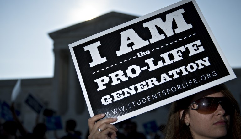 A pro-life advocate holds a sign outside the U.S. Supreme Court before rulings in Washington, D.C., U.S., on Monday, June 27, 2016. A divided U.S. Supreme Court struck down a Texas law that had threatened to close three-quarters of the states abortion clinics by putting new requirements on facilities and doctors.