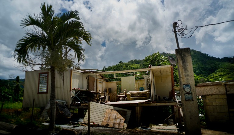 In this Sept. 8, 2018 photo, a home that was abandoned after Hurricane Maria hit one year ago stands full of furniture in the San Lorenzo neighborhood of Morovis, Puerto Rico. Puerto Ricans living below the poverty line were pushed to the brink of despair by the storm, struggling for food, housing and medicine.