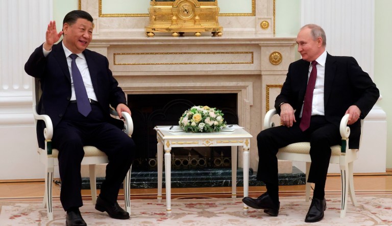 Russian President Vladimir Putin and Chinese President Xi Jinping shake hands. 