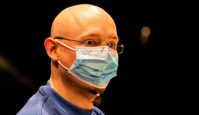 The defendant Yves R. sits in the riding hall converted into a courtroom in the run-up to the pronouncement of the verdict against him in Offenburg, Germany, Friday, Feb. 19, 2021. The man who disarmed four police officers and then hid in Germany's Black Forest for five days last year was convicted Friday of hostage-taking among other offenses and sentenced to three years in prison. 