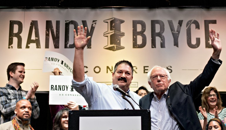 Randy Bryce, Democratic U.S. Representative candidate from Wisconsin, center left, and Senator Bernie Sanders, an Independent from Vermont, center right, wave to attendees during a campaign rally for Bryce in Racine, Wisconsin, U.S., on Saturday, Feb. 24, 2018.