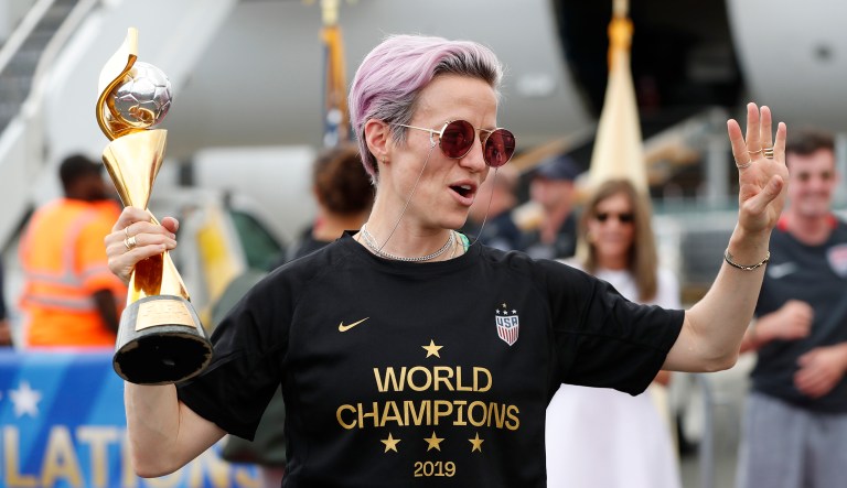 Megan Rapinoe holds the Women's World Cup trophy after she and other members of the U.S. women's national soccer team, winners of a fourth Women's World Cup, celebrated after arriving at Newark Liberty International Airport, Monday, July 8, 2019, in Newark, N.J.