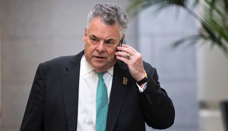 Rep. Peter King, R-N.Y. talks on his phone as he walks on Capitol Hill in Washington.