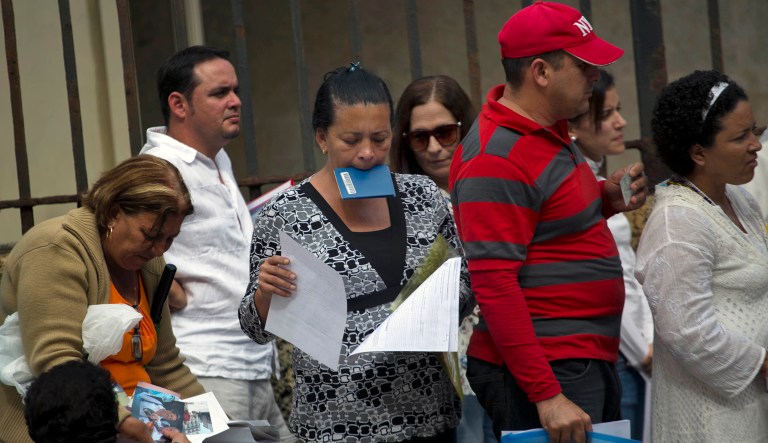 People line up with their documents at the U.S. Interests Section to apply for U.S. travel visas, or the Cuban family reunification program in Havana, Cuba, Wednesday, Jan. 8, 2014.