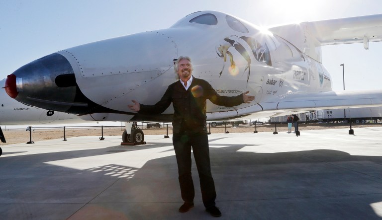 In this Sept. 25, 2013, file photo, British entrepreneur Richard Branson poses with SpaceShipTwo at a Virgin Galactic hangar at Mojave Air and Space Port in Mojave, Calif.
