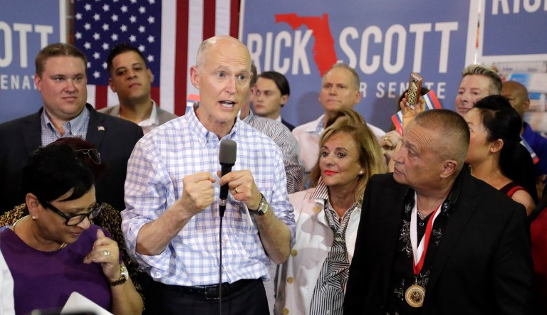 Fla. Gov. Rick Scott, center, candidate for the U.S. Senate speaks to supporters at a campaign rally Tuesday, Sept. 18, 2018, in Orlando, Fla.