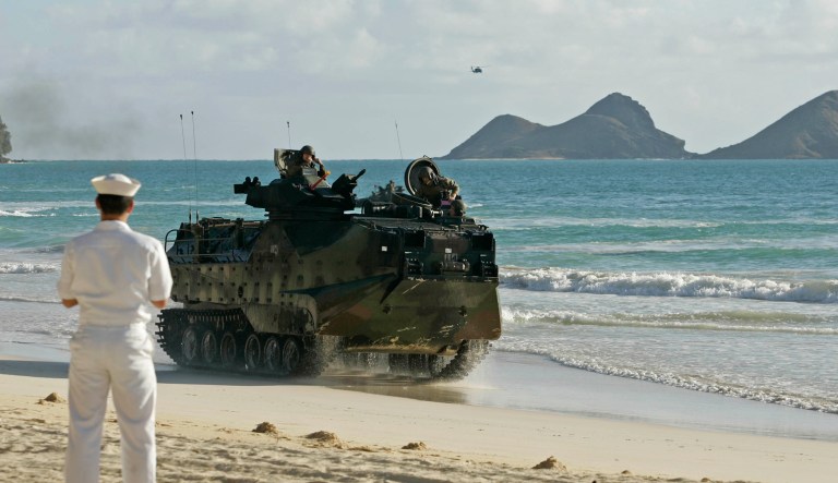 U.S. Navy seaman Byung Cho observes an LAV amphibious assault vehicle rolling down the beach at Marine Corps Training Area Bellows as part of the Rim of the Pacific exercises Saturday, July 22, 2006, in Waimanalo, Hawaii. A Marine Corps Battalion Landing Team conducted an amphibious landing on the Oahu beach as part of the ongoing RIMPAC exercise. More than 40 ships from eight nations are participating in the world's largest sea-based multinational war games, which gather some 19,000 troops, 160 aircraft and six submarines for exercises lasting through late July.