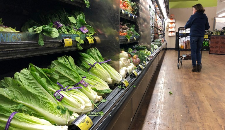 Romaine Lettuce still sits on the shelves as a shopper walks through the produce area of an Albertsons market Tuesday, Nov. 20, 2018, in Simi Valley, Calif. Health officials in the U.S. and Canada told people Tuesday to stop eating romaine lettuce because of a new E. coli outbreak. 