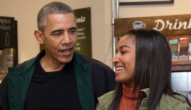 President Barack Obama looks to his daughter Sasha, as they order at Pleasant Pops on Small Business Saturday in Washington, Saturday, Nov. 28, 2015.
