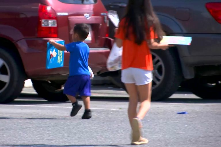 Children walk away with meals and books delivered by Calhoun City Schools staff members and volunteers in Calhoun, Georgia on Thursday, March 19, 2020 after schools closed due to the coronavirus. 