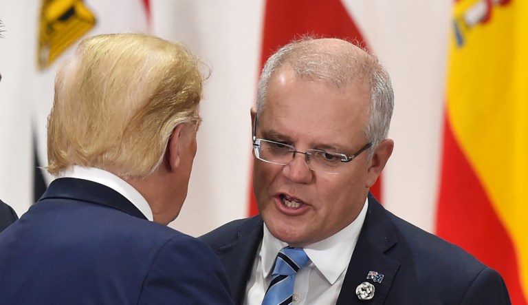 Scott Morrison, Australia's prime minister, right, speaks with U.S. President Donald Trump, center, as Mathias Cormann, Australia's finance minister, left, stands prior to a session at the Group of 20 (G-20) summit in Osaka, Japan, on Saturday, June 29, 2019. Disputes over wording on climate change and trade are unresolved shortly before Group of 20 leaders are due to release a communique from their summit in Japan, raising the risk of a very watered-down document or no statement at all.