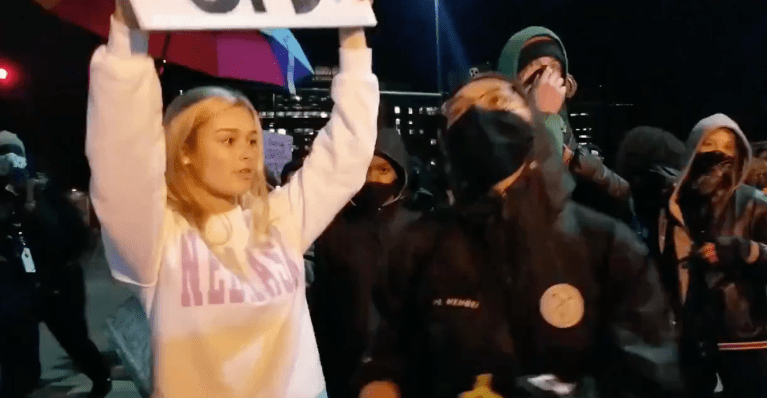 Protesters seen hurling insults and following young woman holding pro-police sign in Omaha