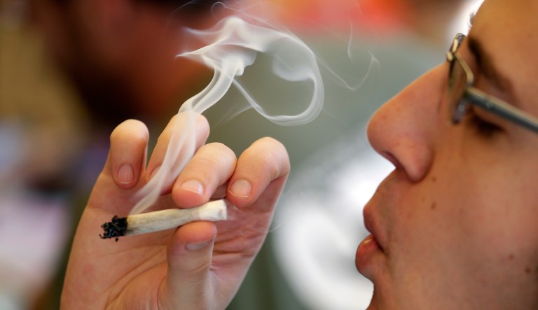 In this April 20, 2016, file photo, a man smokes a marijuana joint at a party celebrating weed in Seattle.