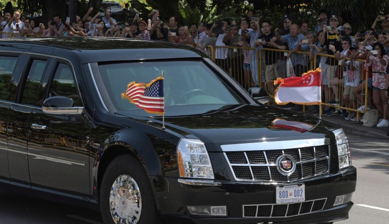 Crowds watch as the limousine of U.S. President Donald Trump arrives at the Istana or Presidential Palace in Singapore on Monday, June 11, 2018, before meeting Singapore Prime Minister Lee Hsien Loong ahead of the summit with North Korea leader Kim Jong Un. 