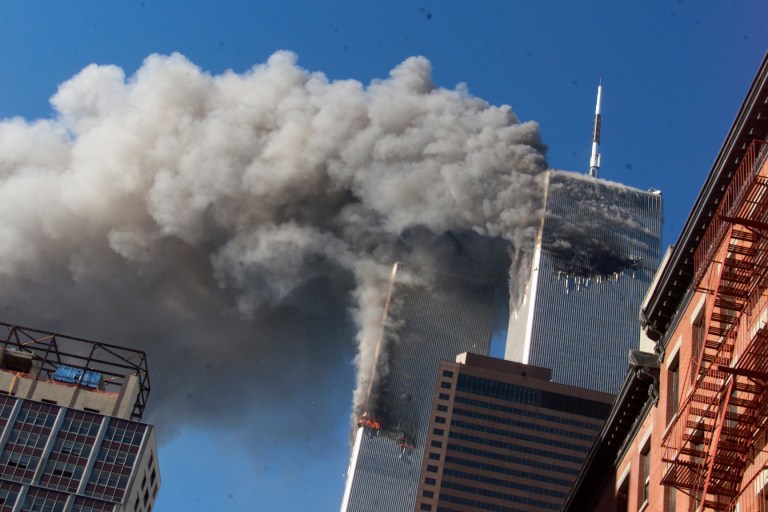 In this Sept. 11, 2001, photo, smoke rises from the burning Twin Towers of the World Trade Center after hijacked planes crashed into the towers, in New York City. The coronavirus pandemic has reshaped how the United States is observing the anniversary of 9/11.