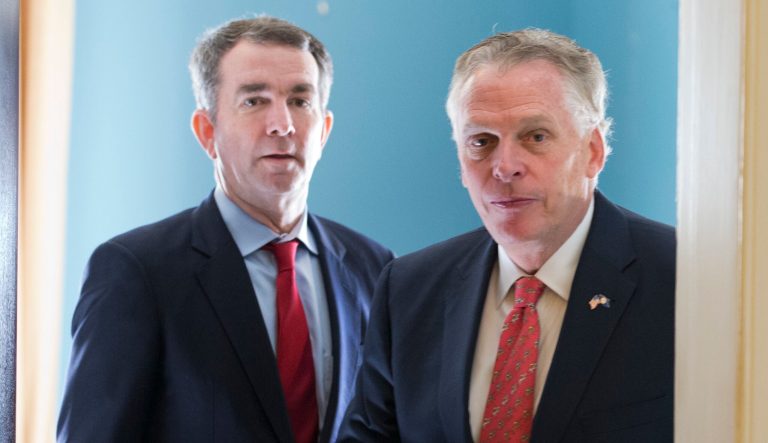 Virginia Gov. Terry McAuliffe, right, arrives for a press conference along with Gov.-elect, Lt. Gov. Ralph Northam, at the Capitol in Richmond, Va., Tuesday, Jan. 9, 2018.