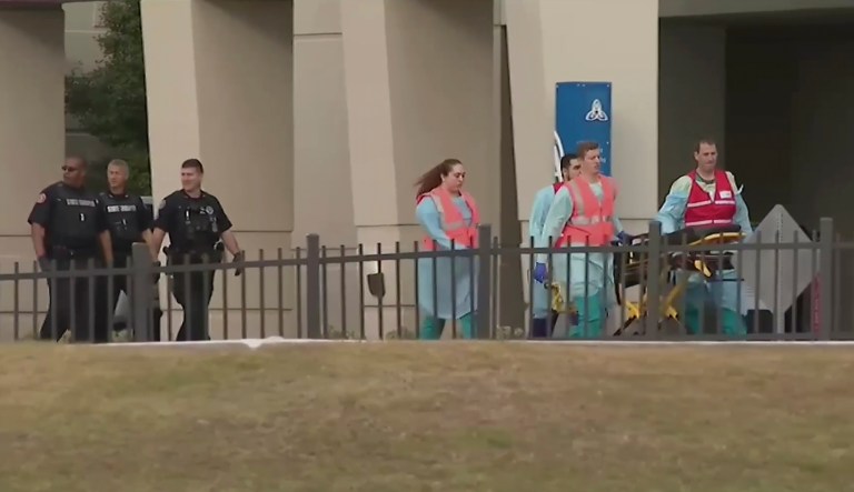 This photo taken from video provided by WEAR-TV shows emergency responders near the Naval Air Base Station in Pensacola, Fla., Friday, Dec. 6, 2019.  The US Navy is confirming that an active shooter and one other person are dead after gunfire at the Naval Air Station in Pensacola. Area hospital representatives tell The Associated Press that at least 11 people were hospitalized. The base remains locked down amid a huge law enforcement response.