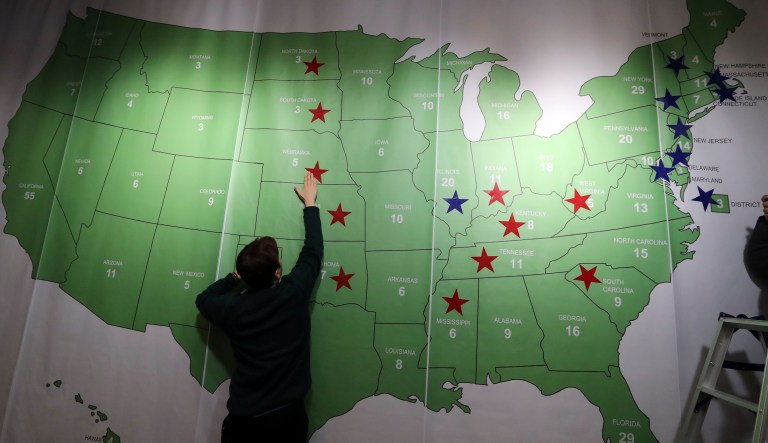 A man puts a sticker on an electoral map during an election watch event hosted by the U.S. Embassy in Seoul, South Korea, Nov. 9, 2016.
