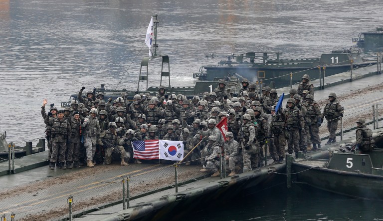 FILE - In this Dec. 10, 2015 file photo, U.S. and South Korean army soldiers pose on a floating bridge on the Hantan river after a river crossing operation, part of an annual joint military exercise between South Korea and the United States against a possible attack from North Korea, in Yeoncheon, south of the demilitarized zone that divides the two Koreas, South Korea. The Pentagon on Monday, June 18, 2018, formally suspended a major military exercise planned for August with South Korea, a much-anticipated move stemming from President Donald Trump's nuclear summit with North Korean leader Kim Jong Un.