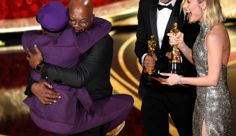 Samuel L. Jackson, center left, embraces Spike Lee, winner of the award for best adapted screenplay for "BlacKkKlansman" as Brie Larson, right, looks on, at the Oscars on Sunday, Feb. 24, 2019, at the Dolby Theatre in Los Angeles.
