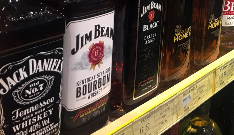 A worker sits near a shelve displaying bottles of American whiskey for sale at a supermarket in Beijing, Wednesday, April 4, 2018. President Donald Trump says the U.S. lost a trade war with China "years ago." In a tweet Wednesday after China announced a list of U.S. products that might be subject to a 25 percent tariff, Trump said: "We are not in a trade war with China, that war was lost many years ago by the foolish, or incompetent, people who represented the U.S." China announced tariffs worth $50 billion on a series of U.S. products including soybeans, whiskey and cars.