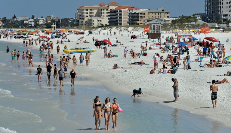 Visitors enjoy Clearwater Beach, Wednesday, March 18, 2020, in Clearwater Beach, Fla. Beach goers are keeping a safe distance from each other to help protect from the spread of the Coronavirus.
