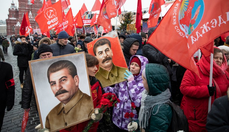Communist supporters hold portraits of Soviet leader Josef Stalin as they queue to lay flowers at the grave of Stalin to mark the 139th anniversary of his birth, in Moscow's Red Square, Russia, Friday, Dec. 21, 2018.