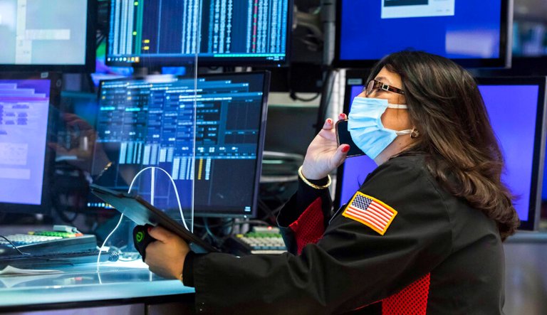 In this photo provided by the New York Stock Exchange, trader Phyllis Arena Woods works on the floor, Monday, Jan. 24, 2022. The Dow Jones Industrial Average dropped more than 1,000 points Monday as financial markets buckled in anticipation of inflation-fighting measures from the Federal Reserve and fretted over the possibility of conflict between Russia and Ukraine.