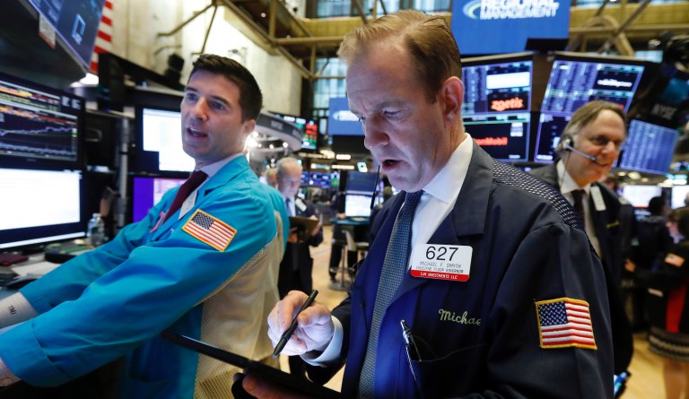 Specialist Thomas McArdle, left, and trader Michael Smyth, center, work on the floor of the New York Stock Exchange.