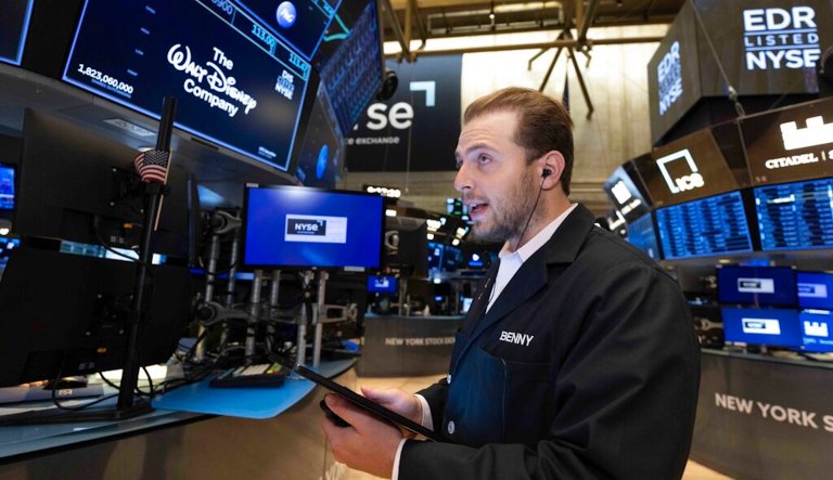 Peter Tuchman, center, works with fellow traders on the floor of the New York Stock Exchange, on Friday. Stocks opened broadly lower on Wall Street, a day after a massive surge, as a number of big companies reported disappointing results.