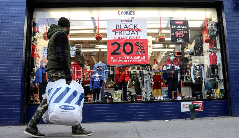 People walk by a Black Friday promotional at Cookie's department store Friday Nov. 29, 2019, in the Brooklyn Borough of New York. 