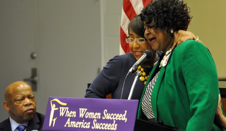 Rep. John Lewis of Georgia, left, listens during an emotional appeal by participant Tonya Pinkston, right, who embraces moderator Mo Ivery at a womenÃ­s forum to bring attention to equal pay, balancing work and family, and the need for affordable child care, on Thursday, Feb. 20, 2014, in Atlanta. 