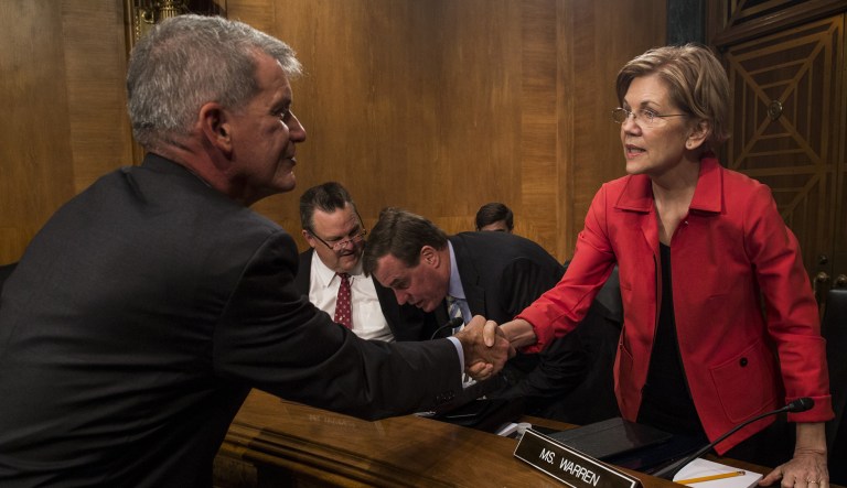 Tim Sloan, chief executive officer and president of Wells Fargo & Co., shakes hands with Senator Elizabeth Warren, a Democrat from Massachusetts, right, before testifying at a Senate Banking, Housing and Urban Affairs Committee hearing in Washington, D.C., U.S., on Tuesday, Oct. 3, 2017. After a "humbling and challenging" year, SloanÂ is set to outline the steps the bank has taken in response to its bogus-accounts scandal that brought down his predecessor,Â John Stumpf. 