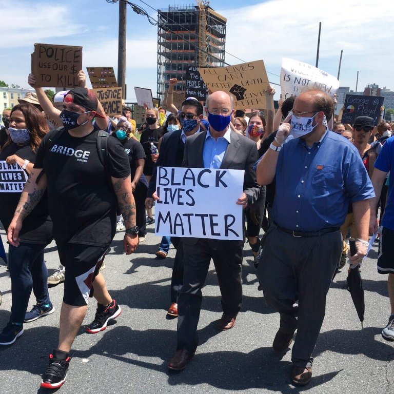Gov. Tom Wolf, holds a "black lives matter" sign while walking alongside Harrisburg Mayor Eric Papenfuse, right, marches with demonstrators protesting police violence against black people and racial injustice following the killing of George Floyd, Wednesday, June 3, 2020 in Harrisburg, Pa. (AP Photo/Mark Scolforo)