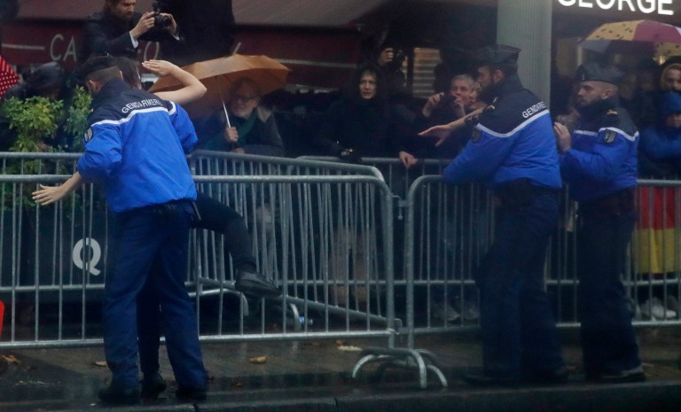 French police officers apprehend a topless protester who ran toward the motorcade of President Donald Trump who was headed on the Champs Elysees to an Armistice Day Centennial Commemoration at the Arc de Triomphe, Sunday Nov. 11, 2018, in Paris. The feminist activist group FEMEN claimed responsibility for the protest. (AP Photo/Jacquelyn Martin)