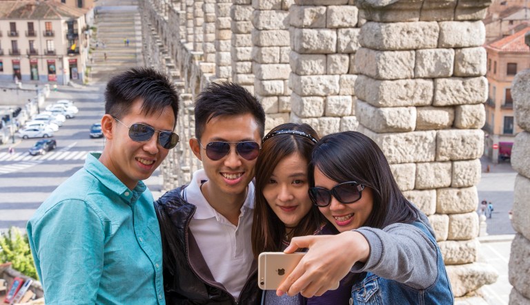 Tourists from China take pictures at the New England Aquarium in Boston. In cities across the country, the American hospitality industry is stepping up efforts to make Chinese visitors feel more welcome.