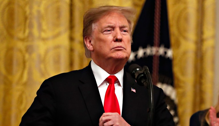 President Donald Trump adjusts his blazer as he speaks before signing an executive order requiring colleges to certify that their policies support free speech as a condition of receiving federal research grants, Thursday March 21, 2019, in the East Room of the White House in Washington.