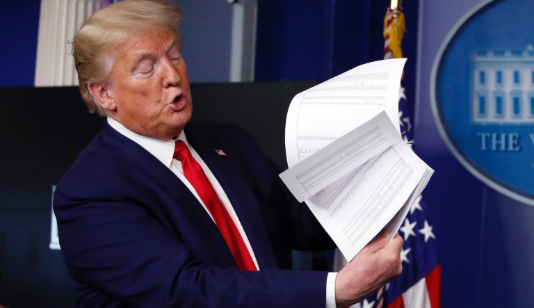 President Donald Trump flips through a stack of papers as he speaks about the coronavirus in the James Brady Press Briefing Room of the White House, Monday, April 20, 2020, in Washington.