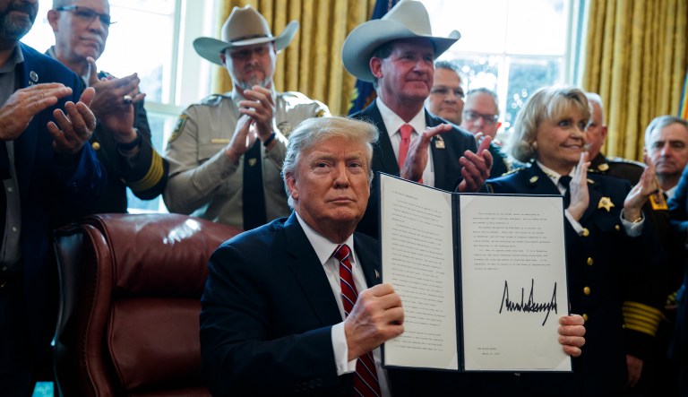 President Donald Trump signs the first veto of his presidency in the Oval Office of the White House, Friday, March 15, 2019, in Washington. Trump issued the first veto, overruling Congress to protect his emergency declaration for border wall funding.