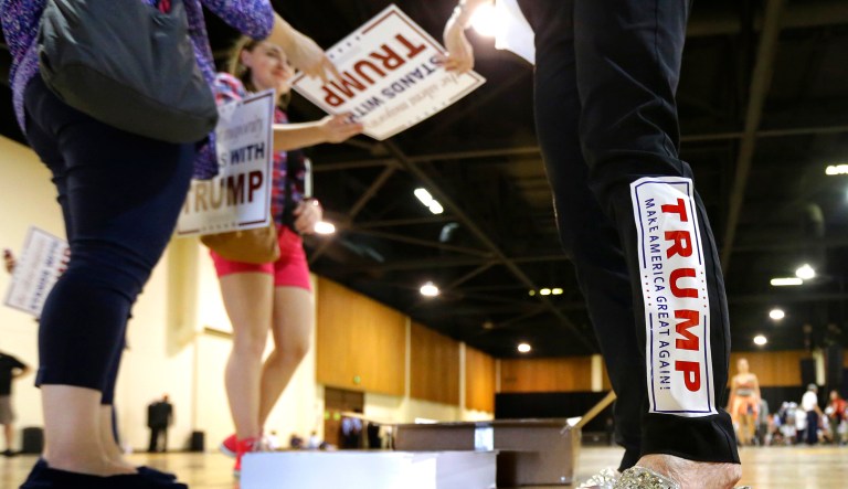 Volunteer Donna Cowan wears a Donald Trump bumper sticker on her leg as she hands out signs before a the start of a rally for the Republican presidential candidate in Eugene, Ore., Friday, May 6, 2016.