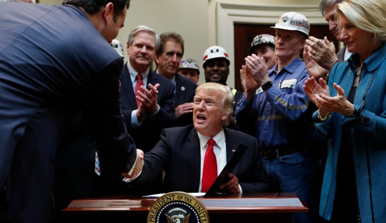 President Donald Trump, joined by coal miners and members of congress including Rep. Jim Renacci, R-Ohio, Sen. Joe Manchin, D-W.Va., and Sen. Shelley Moore Capito, R-W.Va., is congratulated after signing H.J. Res. 38 in the Roosevelt Room of the White House in Washington, Thursday, Feb. 16, 2017.