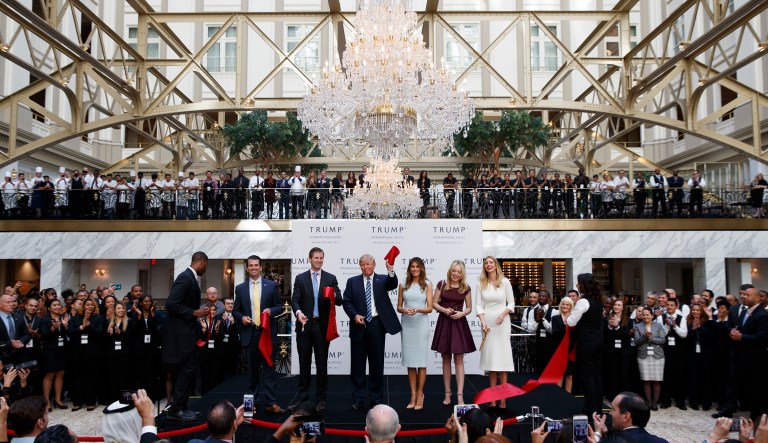 Donald Trump, accompanied by, from left, Donald Trump Jr., Eric Trump, Trump, Melania Trump, Tiffany Trump and Ivanka Trump, holds up a ribbon during the grand opening ceremony of the Trump International Hotel- Old Post Office, in Washington. 