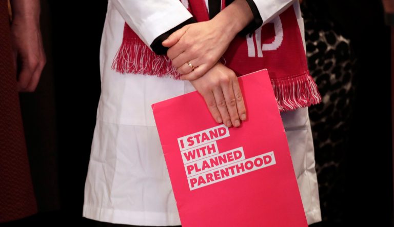 Erin Berry, Washington state medical director for Planned Parenthood of the Great Northwest and the Hawaiian Islands, listens at a news conference announcing a lawsuit challenging the Trump administration's Title X "gag rule" Monday, Feb. 25, 2019, in Seattle.