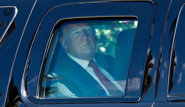 President Donald Trump is seen sitting inside his armored SUV as he departs his Mar-a-Lago estate to attend Easter services at nearby Episcopal Church of Bethesda-by-the-Sea, Sunday, April 21, 2019, in Palm Beach, Fla.