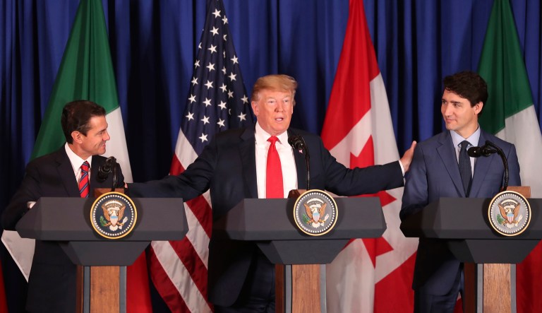 President Donald Trump, center, reaches out to Mexico's President Enrique Pena Nieto, left, and Canada's Prime Minister Justin Trudeau as they prepare to sign a new United States-Mexico-Canada Agreement that is replacing the NAFTA trade deal, during a ceremony at a hotel before the start of the G20 summit in Buenos Aires, Argentina, Friday, Nov. 30, 2018.