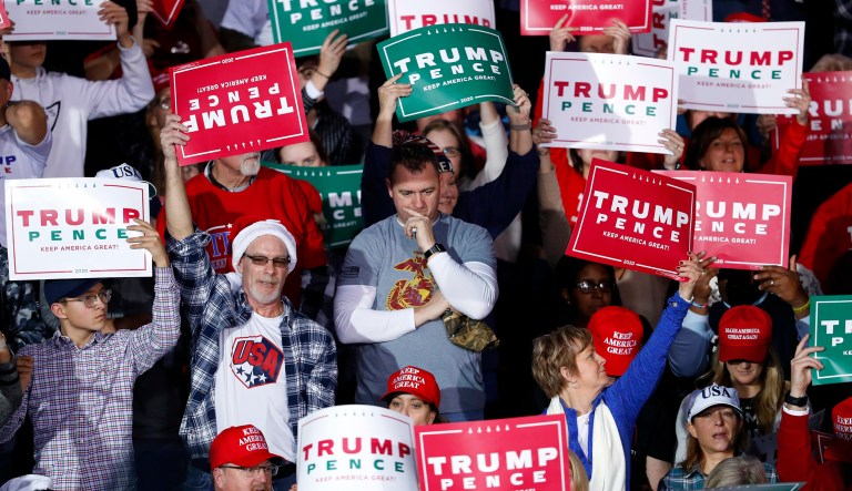 Audience members hold signs at President Donald Trump campaign rally in Battle Creek, Mich., Wednesday, Dec. 18, 2019.