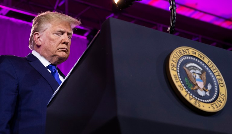 President Donald Trump bows his head down as they say their prayer at the Values Voter Summit in Washington, Saturday, Oct. 12, 2019.