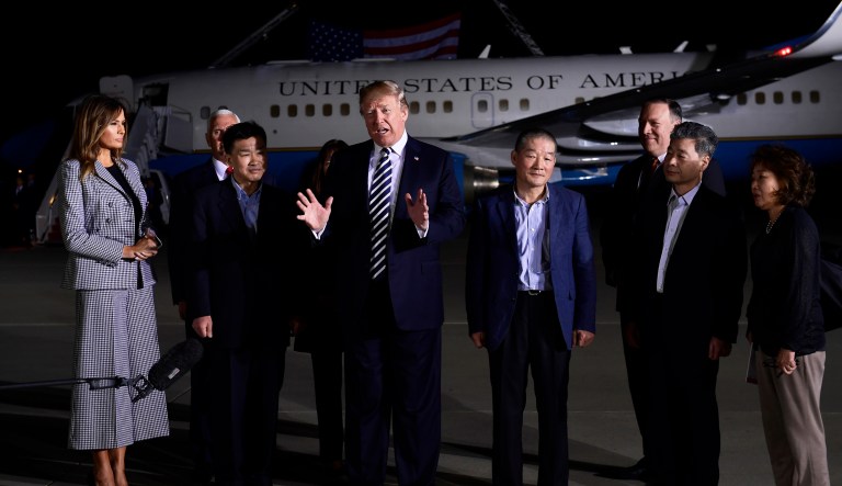 President Donald Trump, center, speaks as he greets Tony Kim, third left, Kim Dong Chul, fourth right, and Kim Hak Song, second right, three Americans detained in North Korea for over a year, as they arrive at Andrews Air Force Base in Md., Thursday, May 10, 2018. First lady Melania Trump, far left, Vice President Mike Pence, behind Tony Kim, and his wife Karen Pence, behind Trump, and Secretary of State Mike Pompeo were also at the air force base to greet them. The woman at right is unidentified.