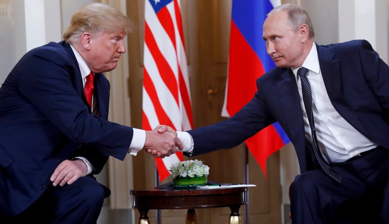 FILE- In this file photo taken on Monday, July 16, 2018, U.S. President Donald Trump, left, and Russian President Vladimir Putin, shake hands at the beginning of a meeting at the Presidential Palace in Helsinki, Finland.  The Kremlin said Wednesday Nov. 28, 2018, it still expects a meeting between President Vladimir Putin and President Donald Trump to go ahead as planned despite a suggestion from Trump that it could be canceled.